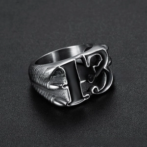 Gros plan sur bague vintage en acier inoxydable avec numéro 13 et griffes de dragon