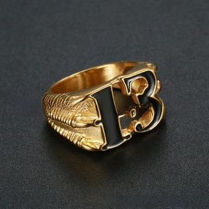 Gros plan détaillé d'une bague en acier doré avec le chiffre 13 et texture de griffe d'aigle