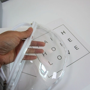 Close-up of a transparent PVC waist bag showing clear material and white zipper