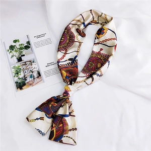 Detailed shot of double-sided silk scarf with chain and tassel patterns on white background