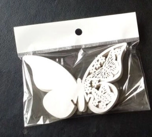 Retail packaging of white laser-cut butterfly cards in clear bag with hanger hook
