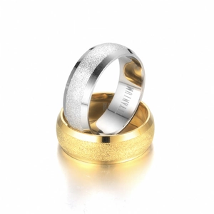 Close-up of matte titanium steel rings in gold and silver showing inner engraving