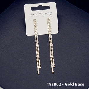 Detailed view of long gold tassel earrings with sparkling white crystals for women