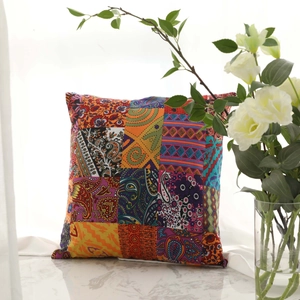Bohemian paisley patchwork linen cushion cover with tassels on a marble table with roses
