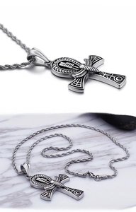 Detail of vintage stainless steel Ankh cross pendant with black engraved Egyptian motifs