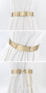 Polished gold mirror metal waist belt with adjustable clasp on a white dress