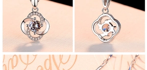 Detail view showing front and back of a silver clover pendant with a rotating center crystal