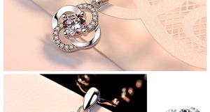 Macro detail of rotating silver clover pendant with clear sparkling crystal inlay