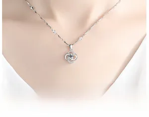 Close-up of 925 silver spinning clover necklace with sparkling crystal on a woman's neck