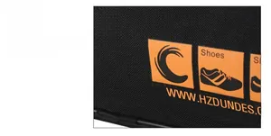 Detail of black breathable mesh material and orange Shoes logo on the travel shoe bag