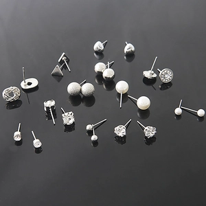 Detail view of silver earring set featuring pearls, crystals, and geometric studs