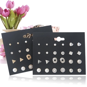 Detailed view of geometric pearl and rhinestone stud earrings set on display cards