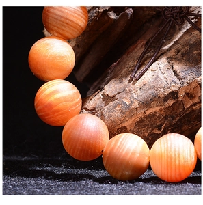 Macro detail of natural wood grain on orange-brown translucent wooden prayer beads
