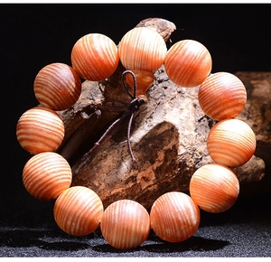 Close-up of translucent blood dragon wood beads with parallel grain and a gourd charm