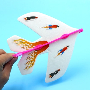 White foam slingshot glider toy with rocket decals held against a blue background