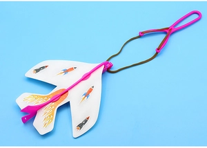 Detail of catapult glider toy with white wings and pink frame against blue background