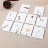 Detail of white Christmas gift boxes with elegant botanical patterns and red seals