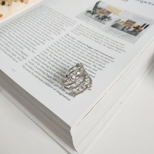 Close-up of a stacked silver zircon ring set elegantly placed on an open book page
