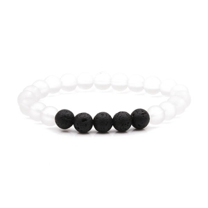 Détail de bracelet élastique avec perles blanches mates de 8mm et pierre de lave