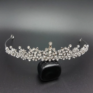 Detailed macro view of a silver bridal crown with sparkling rhinestones on a stone base