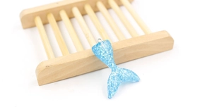 Detailed view of blue resin mermaid tail charm with glitter finish and metal ring