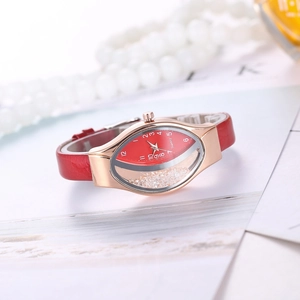 Detail of red leather watch with oval rose gold case and moving sand crystals