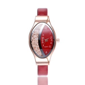 Close-up of red oval quartz watch with floating crystals and rose gold case