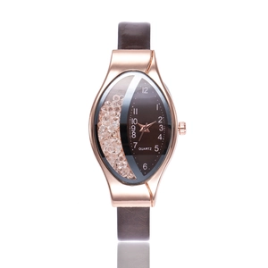 Detail of rose gold oval quartz watch with white crystals and dark brown leather strap
