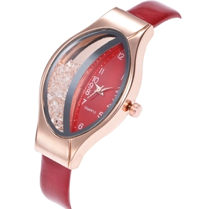 Detail view of oval rose gold quartz watch with red leather strap and floating crystals