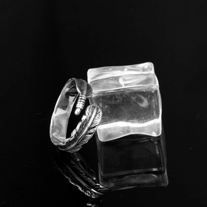 Detailed close-up of oxidized vintage silver feather ring with intricate carved textures