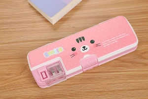 Detail of pink cartoon pencil case with built-in sharpener on a wooden study desk