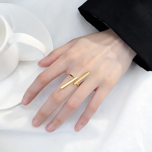 Anello aperto geometrico a doppia barra in oro indossato da una modella