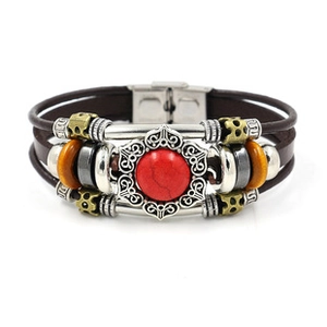 Detail of bohemian multilayer bracelet with brown leather cord and red gemstone charm