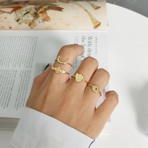 Detail of four-piece gold ring set featuring moon and star designs on a vintage book