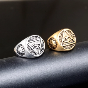Vintage stainless steel Eye of Providence rings in gold and silver finish displayed on a stand