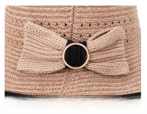 Dettaglio del cappello da sole in paglia kaki con fiocco decorativo e anello in metallo
