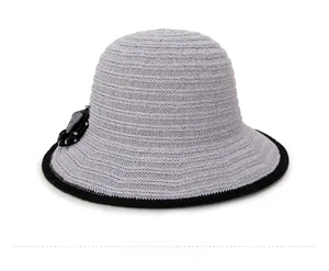 Side view of gray knit sun hat with black bow detail and contrasting edge trim