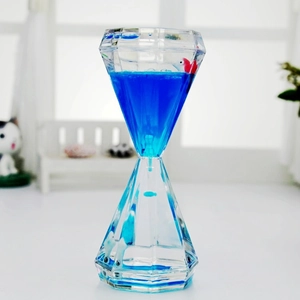 Macro detail of diamond shaped liquid timer with blue oil and decorative fish inside