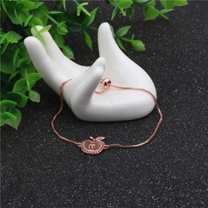 Bracciale regolabile a mela oro rosa con zirconi rossi su modello di mano in ceramica