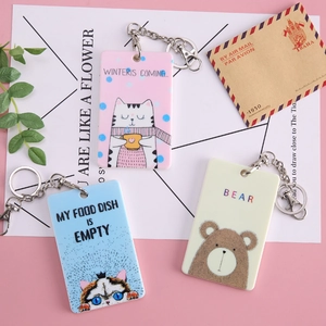 Cute cartoon animal card holders with keychains in cat and bear designs on a pastel background