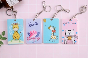 Flat lay of colorful cartoon card holders with giraffe and flamingo patterns and keychains