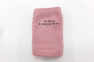 Detail of pink knitted baby kneepads with non-slip texture for safe crawling protection