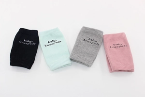Flat lay of four colorful breathable cotton baby kneepads in pink green and grey colors