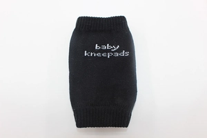 Detail of black knitted cotton baby kneepads with white anti-slip text branding