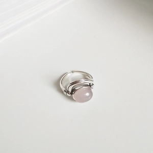 Close-up of vintage 925 silver ring featuring a round rose quartz stone with aged texture