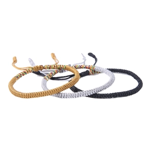 Detailed row of handmade woven knot bracelets in gold silver black and multi colors