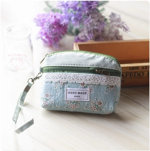 Detailed view of light blue floral cloth coin purse with lace trim and zipper closure