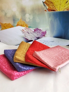 Close-up of four colorful SOIGNE OZ jacquard pouches with premium silk sheen and zippers