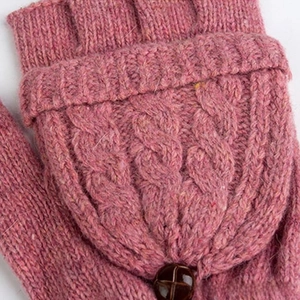 Détail macro de mitaines roses en tricot torsadé montrant la texture et le bouton