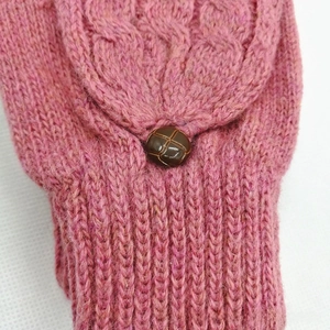 Gros plan de moufles roses en maille torsadée avec un bouton vintage marron détaillé